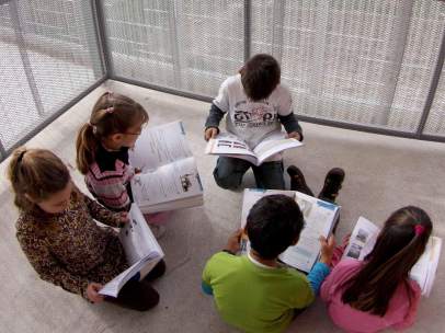 Alumnos leen sus libros de texto