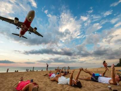 Aviones sobre turistas en la playa de Nai Yang