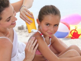 Una mujer aplica protector solar a una niña