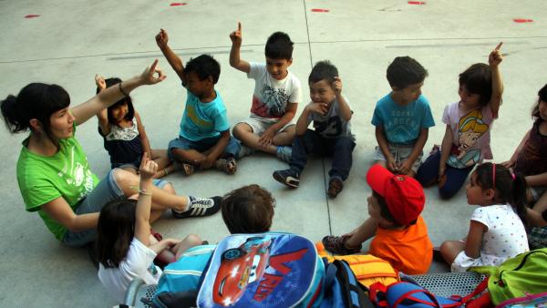 Niños junto a una monitora en el casal de verano de la escuela Fructuós Gelabert de Barcelona. Niños junto a una monitora en el casal de verano de la escuela Fructuós Gelabert de Barcelona.
