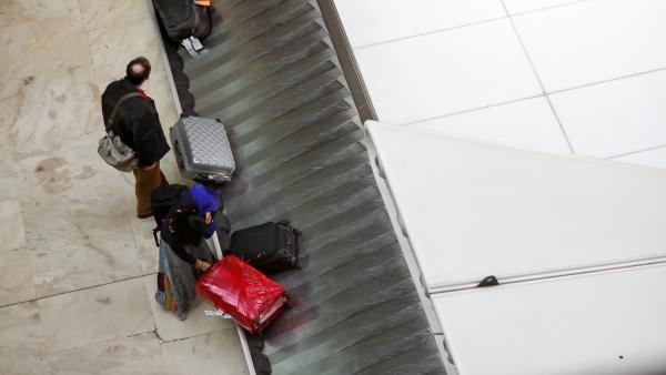 Un pasajero coge su maleta de la cinta transportadora, junto a él, otro viajero espera a que llegue su maleta en el aeropuerto Adolfo Suárez Madrid-Barajas. Un pasajero coge su maleta de la cinta transportadora, junto a él, otro viajero espera a que llegue su maleta en el aeropuerto Adolfo Suárez Madrid-Barajas.