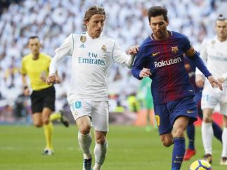 Luka Modric y Leo Messi disputan un balón en el clásico
