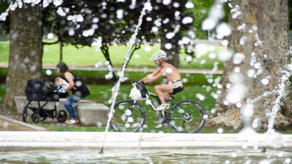 Una fuente y personas en un parque en verano. Una fuente y personas en un parque en verano.