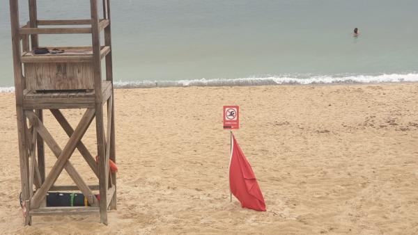 Una playa señalizada con bandera roja por un vertido de aguas mixtas. Una playa señalizada con bandera roja por un vertido de aguas mixtas.