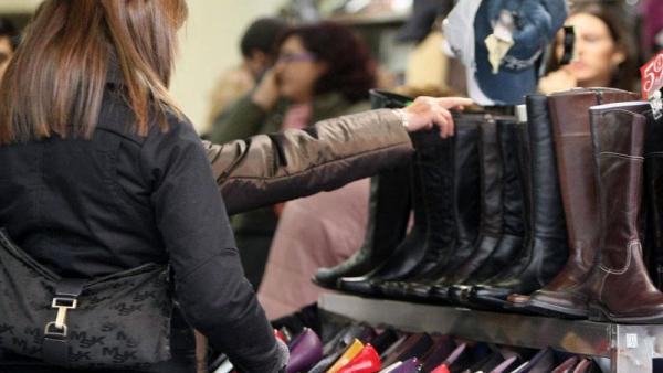 Consumidor comprando botas en una tienda Consumidor comprando botas en una tienda