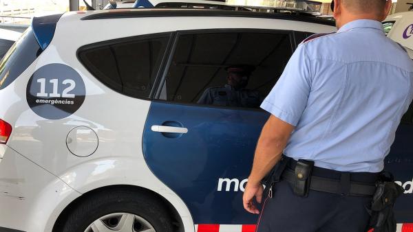 Agente y coche de Mossos d'Esquadra Agente y coche de Mossos d'Esquadra