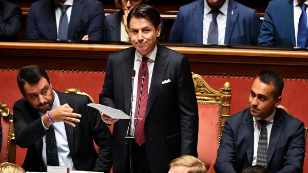 Giuseppe Conti, durante el discurso en que anunció su dimisión, flanqueado por Matteo Salvini (izquierda) y Luigi Di Maio (derecha) Giuseppe Conti, durante el discurso en que anunció su dimisión, flanqueado por Matteo Salvini (izquierda) y Luigi Di Maio (derecha)