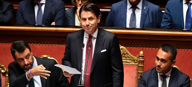 Giuseppe Conti, durante el discurso en que anunció su dimisión, flanqueado por Matteo Salvini (izquierda) y Luigi Di Maio (derecha)