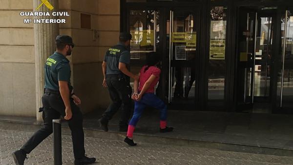 Un agente de la Guardia Civil detiene a una de las implicadas en el caso. Un agente de la Guardia Civil detiene a una de las implicadas en el caso.