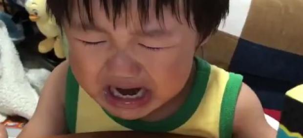 Un niño llora desconsolado porque su madre parte su tarta de cumpleaños