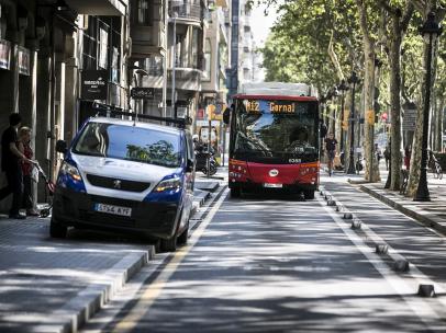 Un autobús urbano de Barcelona circulando por el carril bus lateral de la Gran Via con una furgoneta invadiendo parte de la calzada.