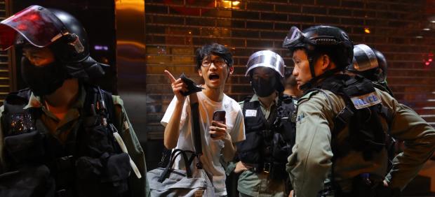 Policías hablando con un manifestante en Hong Kong.