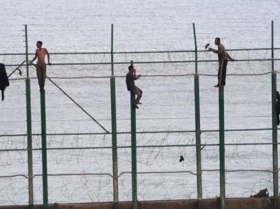 Inmigrantes en la valla fronteriza de Ceuta.